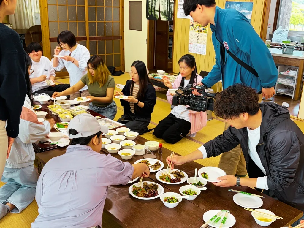 国際家庭料理交流会の試食会で料理を囲む参加者の様子