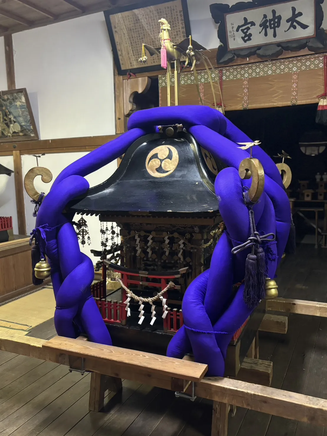 お神明さんの御輿。青い鎮の紐で巻かれ、上部に鳳凰と巴紋。背後に「太神宮」の額が掲げられている。